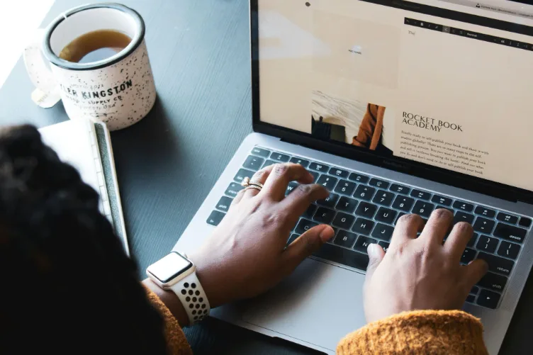 Freelance SEO travaillant sur son ordinateur portable avec un café, en autonomie